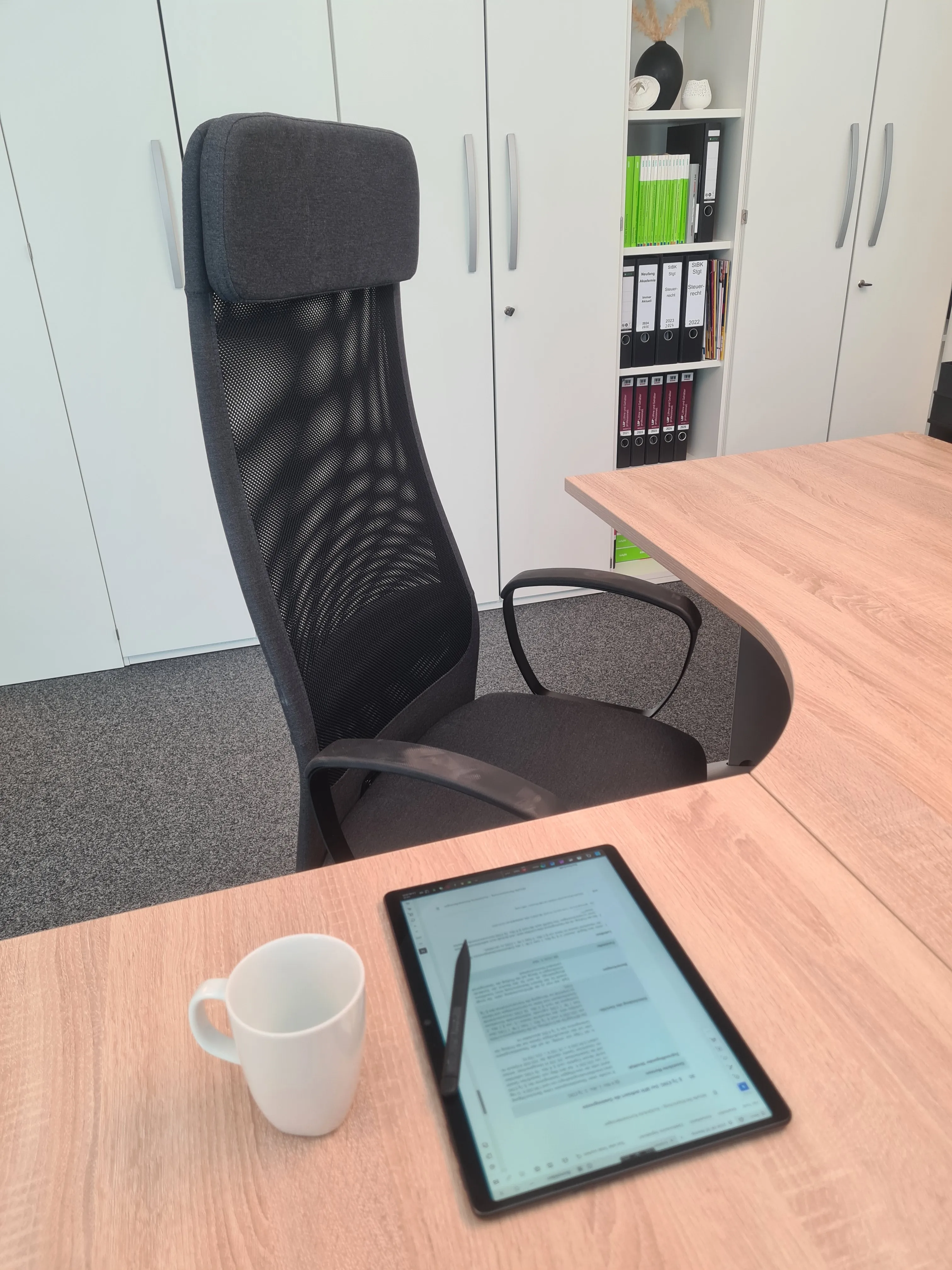 Moderner Arbeitsplatz mit Bürostuhl, Tablet und Kaffeetasse in der Steuerkanzlei Carmen Weinmann